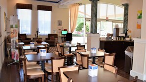 A restaurant with multiple tables and chairs, a counter, and a view of the outdoors. - Quality Inn Conference Center at Citrus Hills (Hernando)
