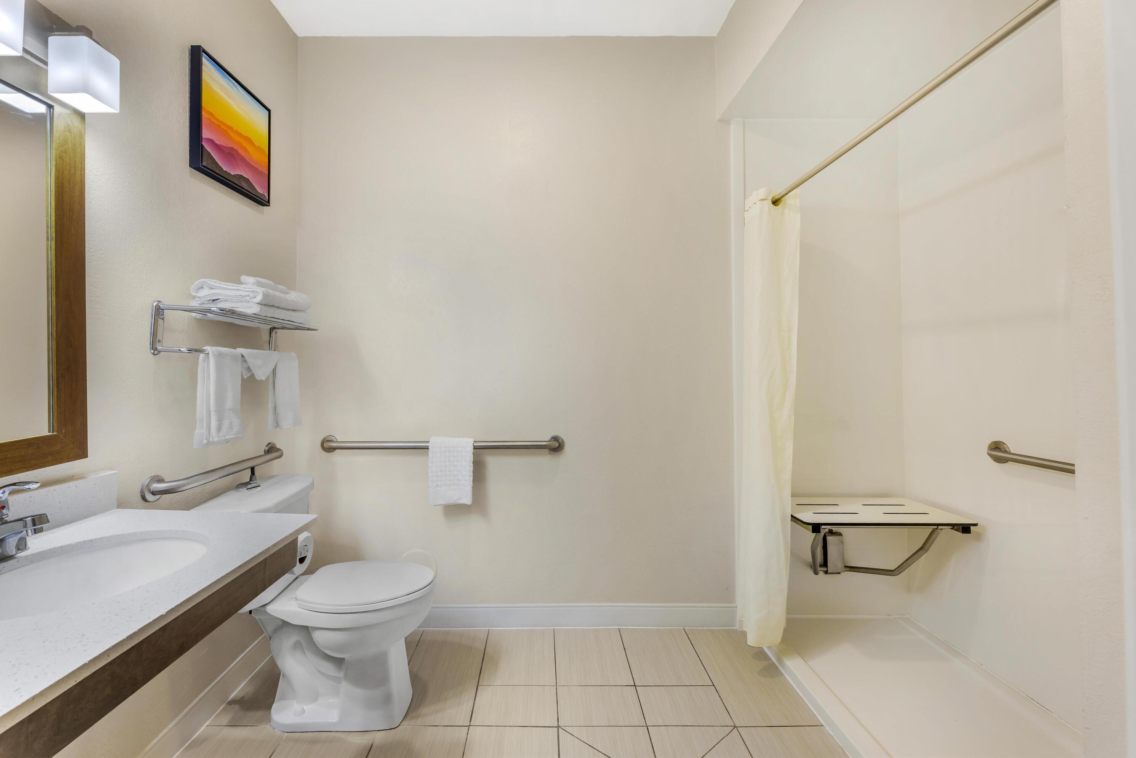 A modern bathroom with a toilet, sink, and shower area.