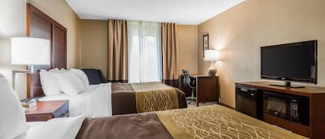 A hotel room with two beds, a desk, a television, and a minibar.