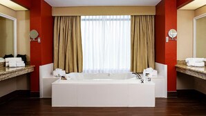 A modern bathroom with a large bathtub, two sinks, and a large window with curtains. - Inn at Coushatta (Kinder)