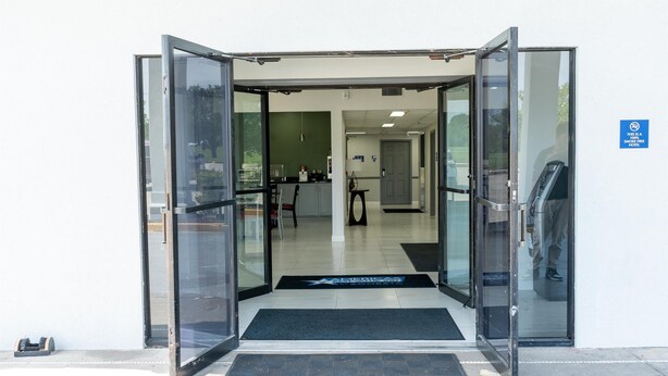 A hotel entrance with a glass door and a black mat. - Americas Best Value Inn Donaldsonville (Donaldsonville)