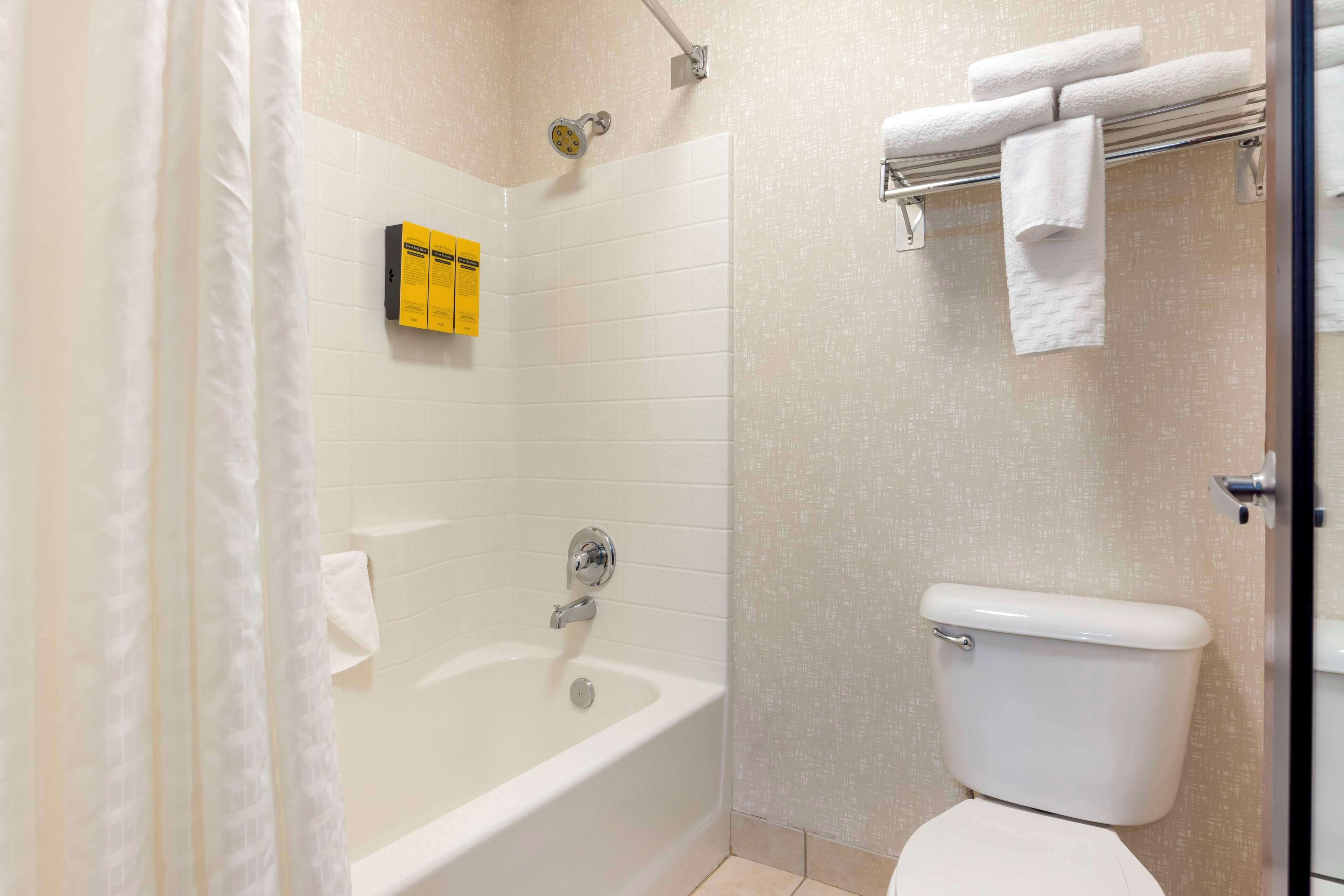 Un baño con bañera, inodoro y perchero para toallas.