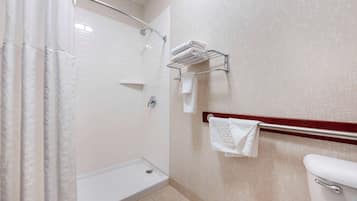 Un baño con ducha, inodoro y perchero para toallas.