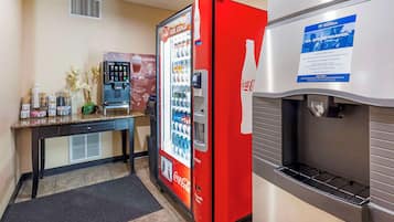 A vending machine with a Coca-Cola logo, a Coca-Cola refrigerator, and a coffee machine.