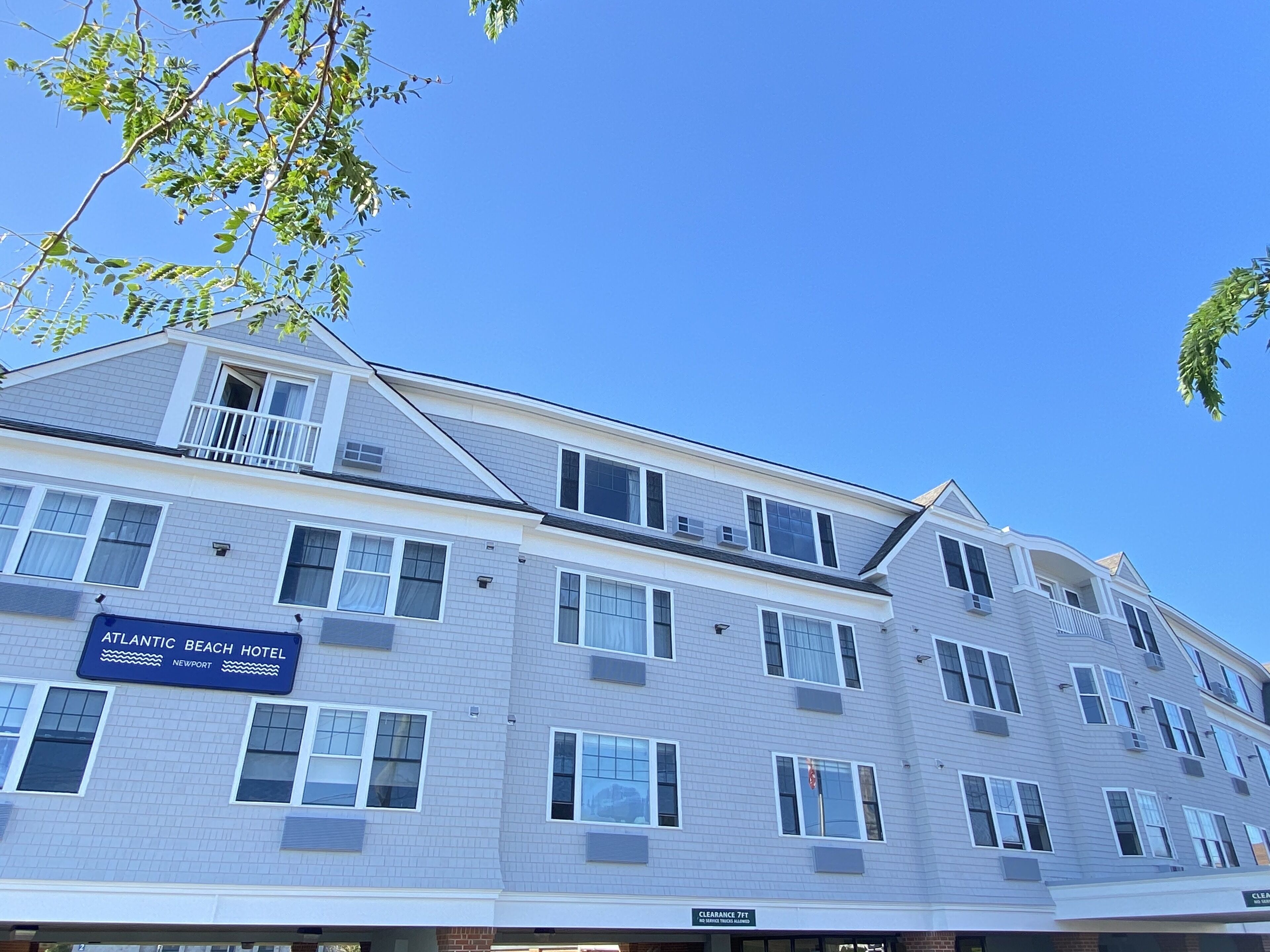 A multi-story hotel with a sign reading "Atlantic Beach Hotel Newport" and a clearance sign indicating 7 feet clearance.