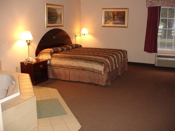 Habitación de hotel con cama, dos lámparas de pared, teléfono, ventana con cortinas y radiador.