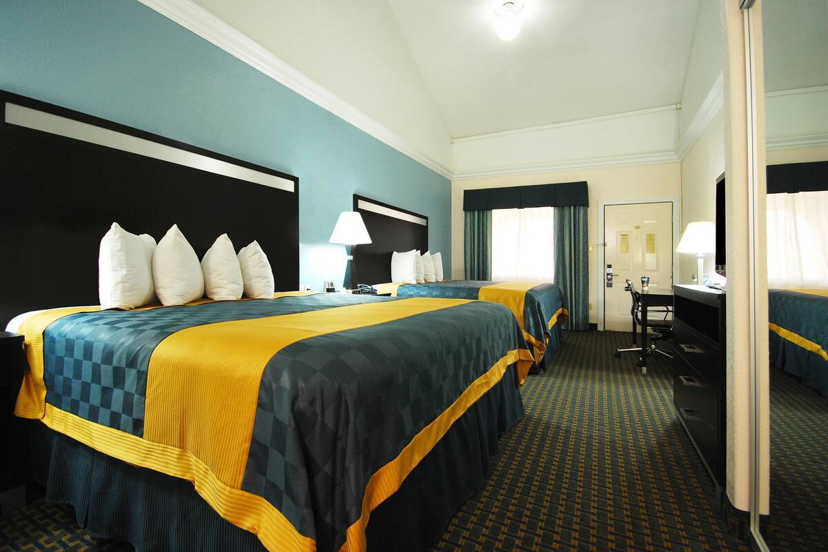 Una habitación de hotel con dos camas, un escritorio y una silla.