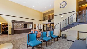 A spacious lobby with a reception desk, seating area, and a staircase. - Best Western Plus DFW Airport Suites (Irving)