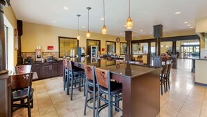 A spacious kitchen with a central island, bar stools, and pendant lighting. - Best Western Plus DFW Airport Suites (Irving)