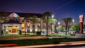 A Best Western Plus hotel with a modern design, multiple parking spaces, and a well-lit entrance. - Best Western Plus DFW Airport Suites (Irving)