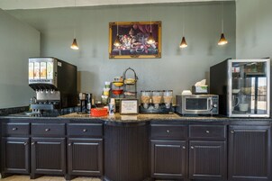 Una cocina con cafetera, microondas y refrigerador.
