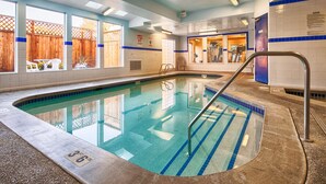 Une piscine dont la profondeur est indiquée par un repère à 36 pouces, entourée d’une terrasse carrelée et d’une clôture en bois.