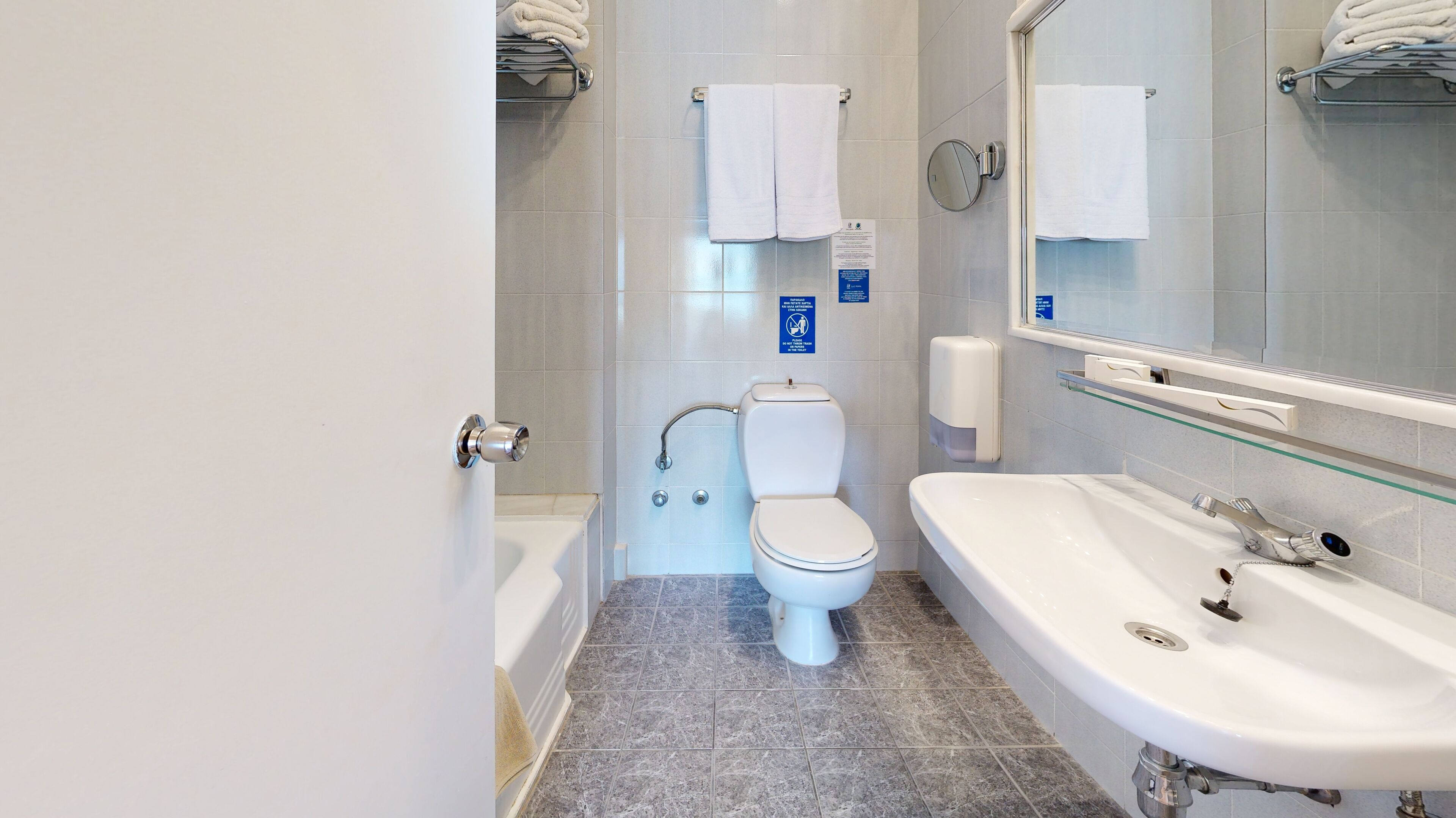 Ein modernes Badezimmer mit Toilette, Badewanne und einem großen Spiegel.