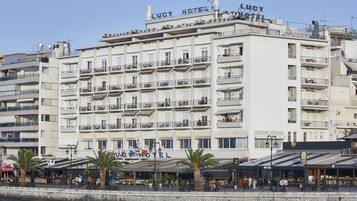 A multi-story hotel with balconies, a waterfront view, and outdoor seating areas.