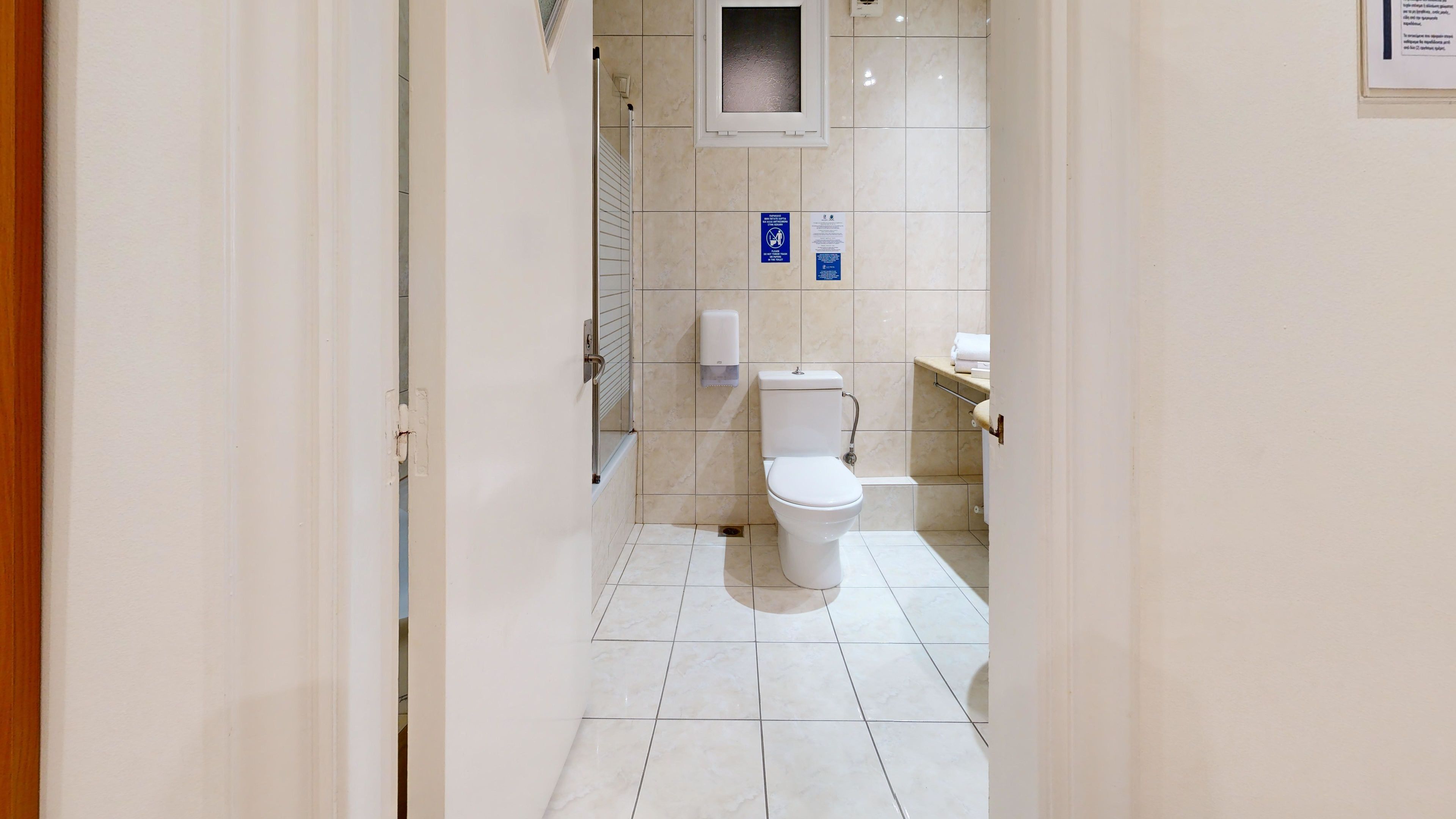 Een moderne badkamer met een toilet, een handdroger en een klein raam.
