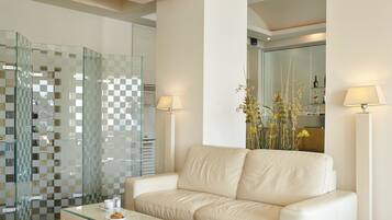 A modern living room with a glass coffee table, a beige sofa, and a glass partition with a checkered pattern.
