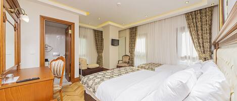 Una habitación de hotel con una cama grande, un escritorio, una silla, un televisor y un armario.