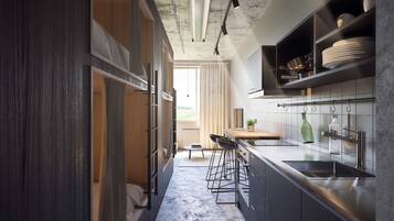 A modern kitchen with dark cabinetry, a stainless steel sink, and a window overlooking a garden.