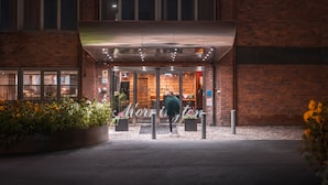 Entrada de hotel con fachada de ladrillo, puertas de vidrio y un letrero que dice "Mornister".