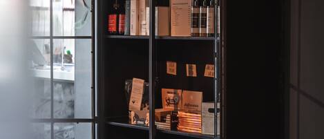 Una estantería metálica con varios objetos, incluyendo libros, un cuadro enmarco y una caja etiquetada