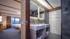 A modern hotel bathroom with a large mirror, two sinks, and a shower area. - Fletcher Hotel De Witte Brug (Lekkerkerk)