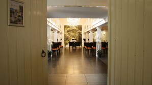 A hotel lobby with a chandelier, wooden paneling, and a piano. - Fletcher Hotel De Witte Brug (Lekkerkerk)