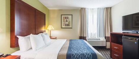 Une chambre d’hôtel équipée d’un lit, d’un bureau, d’une télévision et d’un appareil de climatisation.