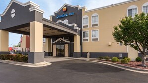 A Comfort Inn hotel with a beige facade, a covered entrance, and a CVS Pharmacy sign in the background.