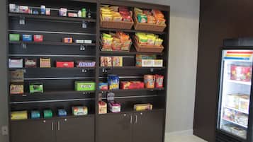 Máquina de vendas automática com variedade de lanches e bebidas.