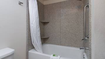 A bathroom with a shower, toilet, and a bathtub.