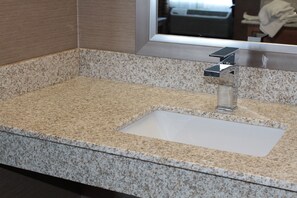 A bathroom with a granite countertop, a rectangular sink, and a modern faucet. - Holiday Inn Express Rocklin - Galleria Area by IHG (Rocklin)