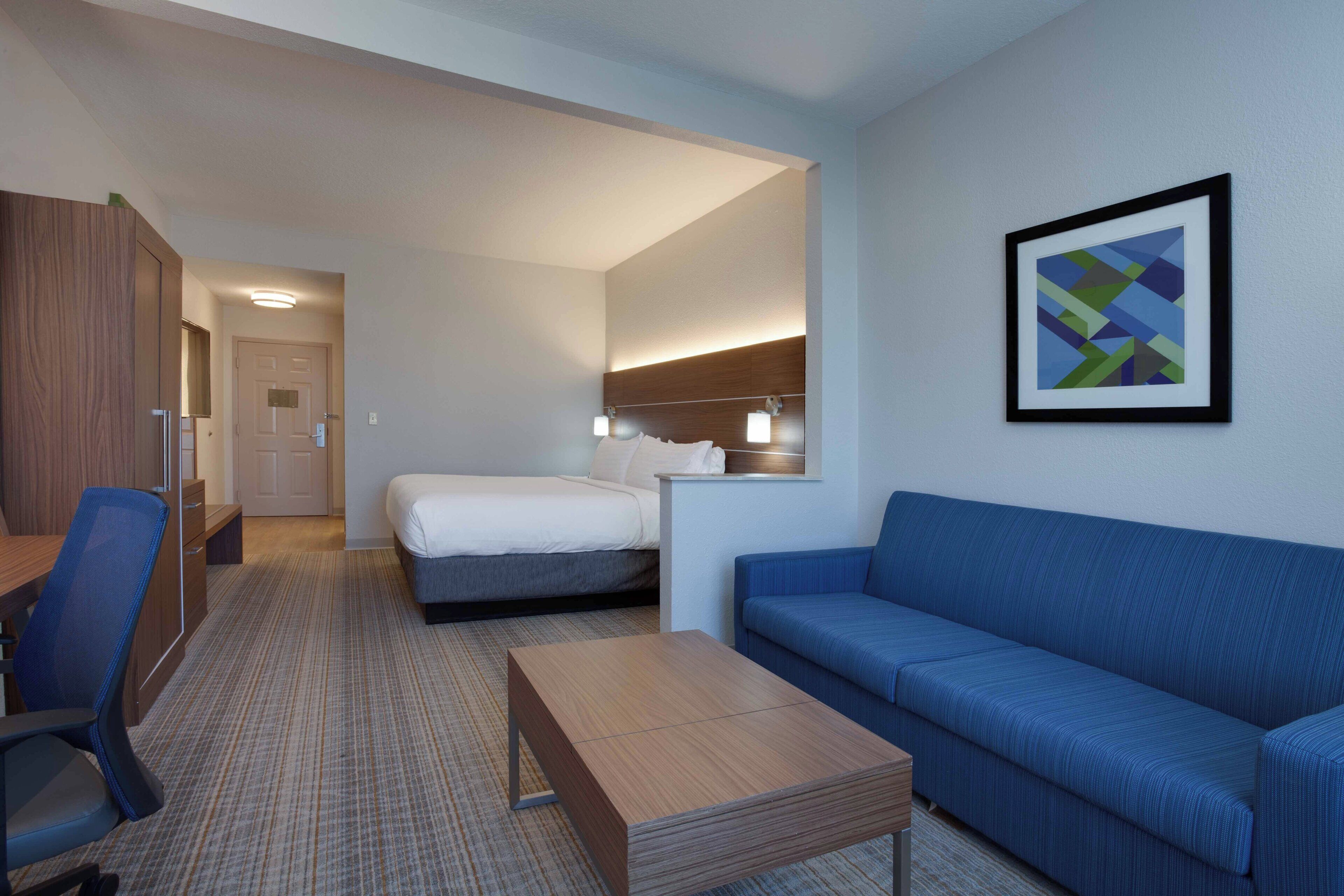 Una habitación de hotel con cama, sofá, escritorio y silla.