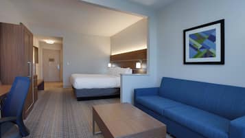 Una habitación de hotel con cama, sofá, escritorio y silla.