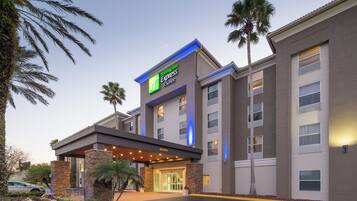Un edificio de Holiday Inn Express con un diseño moderno, que cuenta con una entrada destacada y un paseo techado.