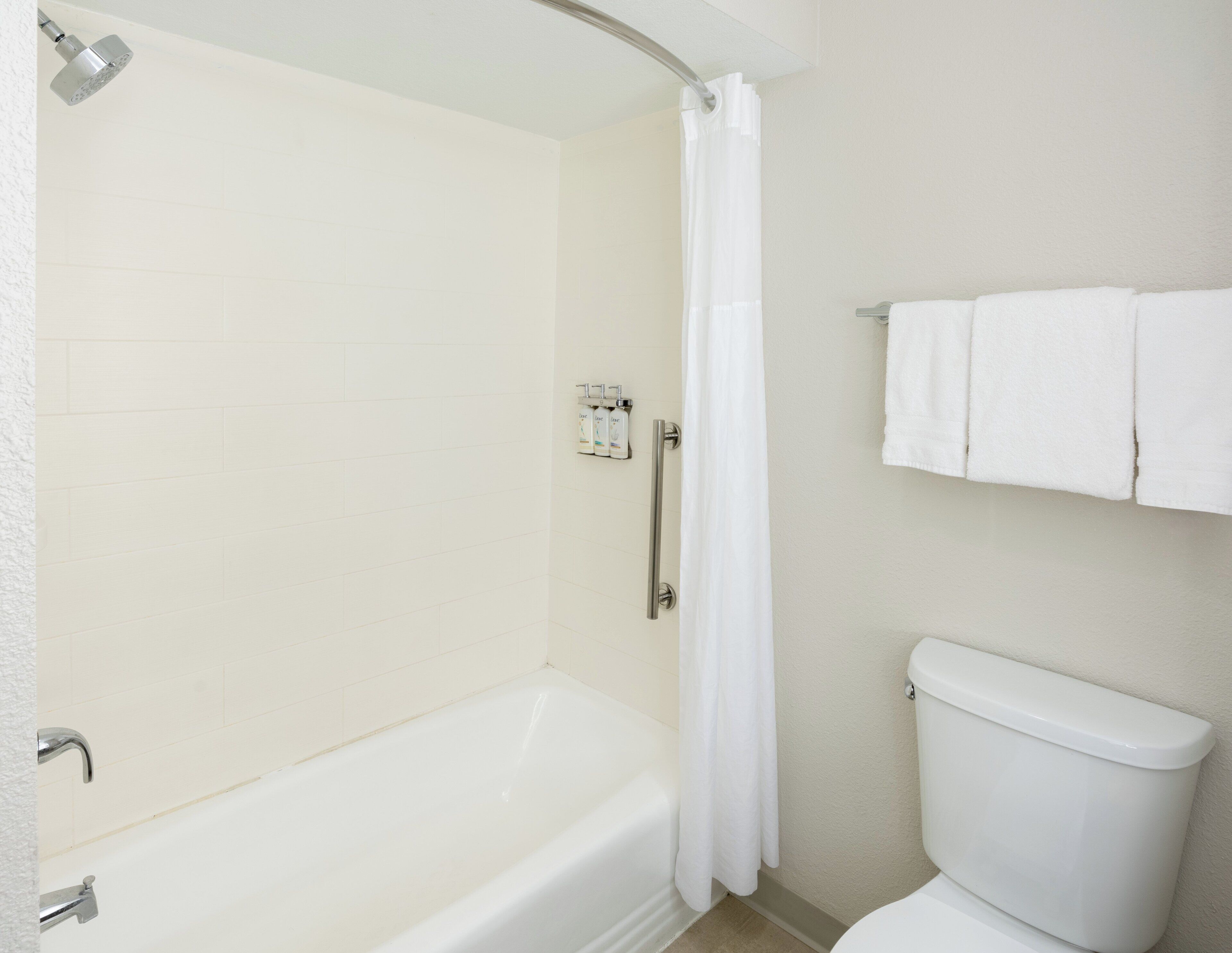 Une salle de bain équipée d’une baignoire, d’une douche, de toilettes et d’un porte-serviettes.