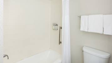 Une salle de bain équipée d’une baignoire, d’une douche, de toilettes et d’un porte-serviettes.