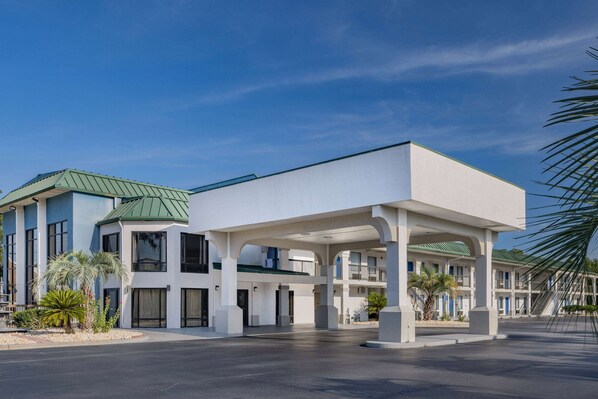 Simple, two-story motel with a flat roof and covered parking area.