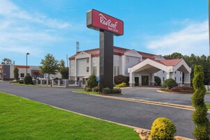 Un hotel Red Roof Inn & Suites con estacionamiento y un edificio con techo rojo.