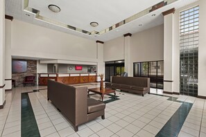A spacious lobby with a reception desk, seating area, and a large window providing natural light. - Red Roof Inn & Suites Newnan (Newnan)