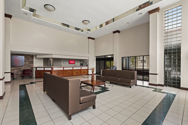 A spacious lobby with a reception desk, seating area, and a large window providing natural light. - Red Roof Inn & Suites Newnan (Newnan)
