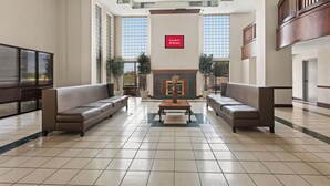 A spacious lobby with two sofas, a central table, and a sign indicating free Wi-Fi in all rooms. - Red Roof Inn & Suites Newnan (Newnan)
