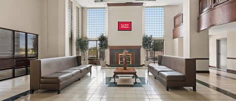 A spacious lobby with two sofas, a coffee table, and a sign indicating free Wi-Fi in all rooms.