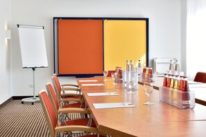 Meetings and celebrations come alive in this well-equipped conference room with a projector screen, whiteboard, and comfortable seating.