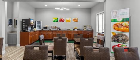 A modern dining area with a kitchen in the background, featuring a buffet setup and a variety of food displays.