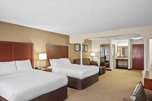 A hotel room with two beds, a desk, a chair, a lamp, and a bathroom visible through an open door. - Comfort Suites Grandville - Grand Rapids SW (Grandville)