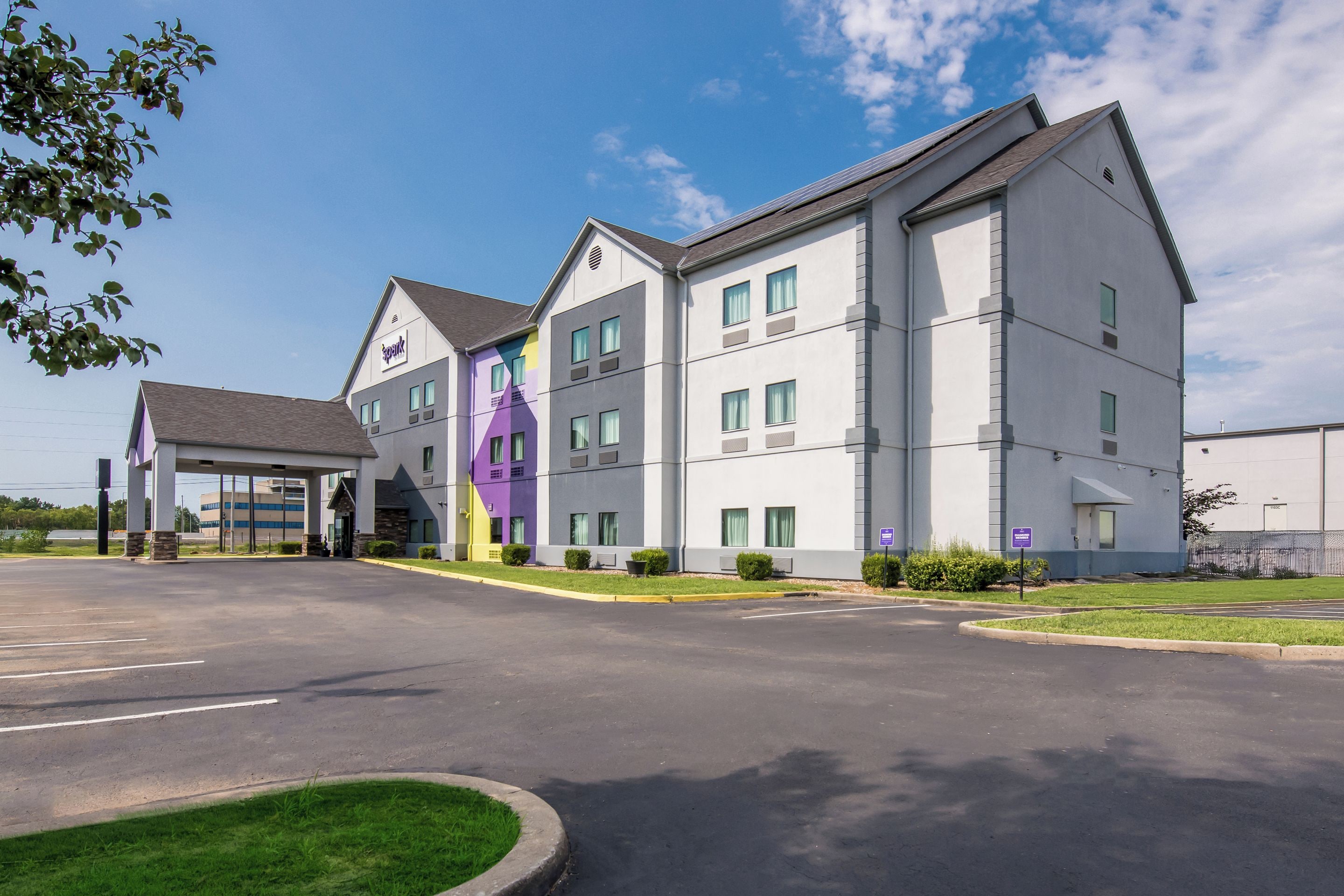 A multi-story hotel with a covered entrance and a parking lot.