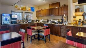 Une cuisine moderne avec des meubles en bois, un îlot central et des chaises à revêtement rouge.