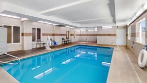 An indoor swimming pool with clear water, a diving board, and a lifeguard chair. - Comfort Inn Elko (Elko)