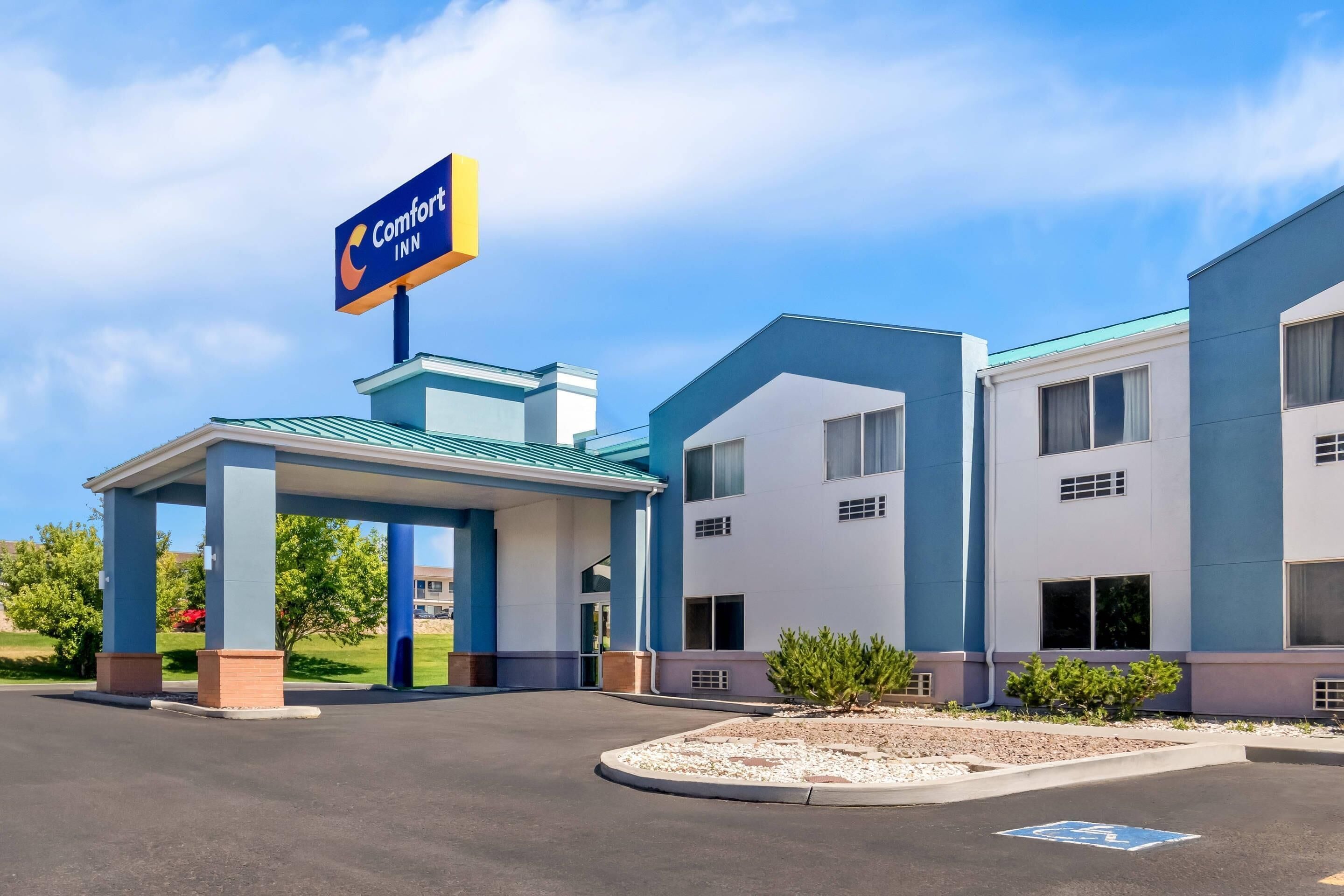 A Comfort Inn hotel with a covered entrance, multiple rooms, and a parking lot.
