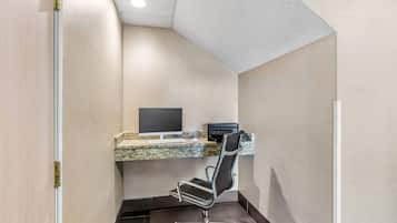 A corner office with a desk, chair, and a computer monitor.